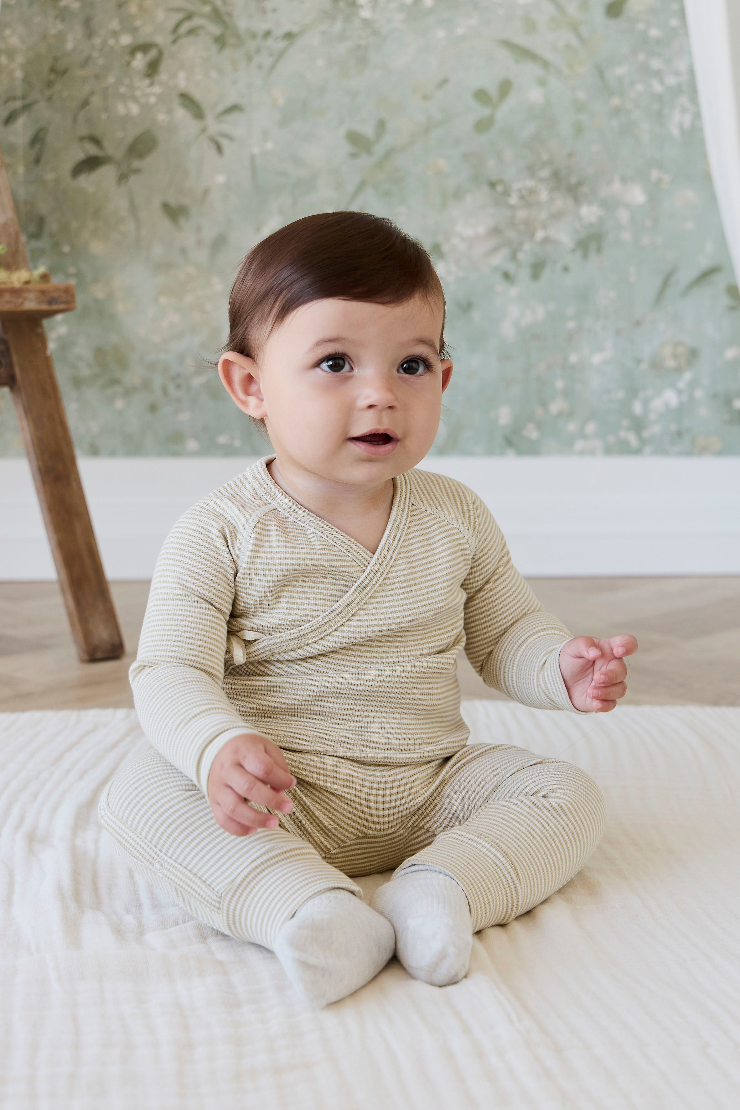Grenouillère douillette en coton à fines côtes et fines rayures crème et marron, à manches longues, avec ouverture portefeuille et revers doux aux chevilles pour nouveau-né