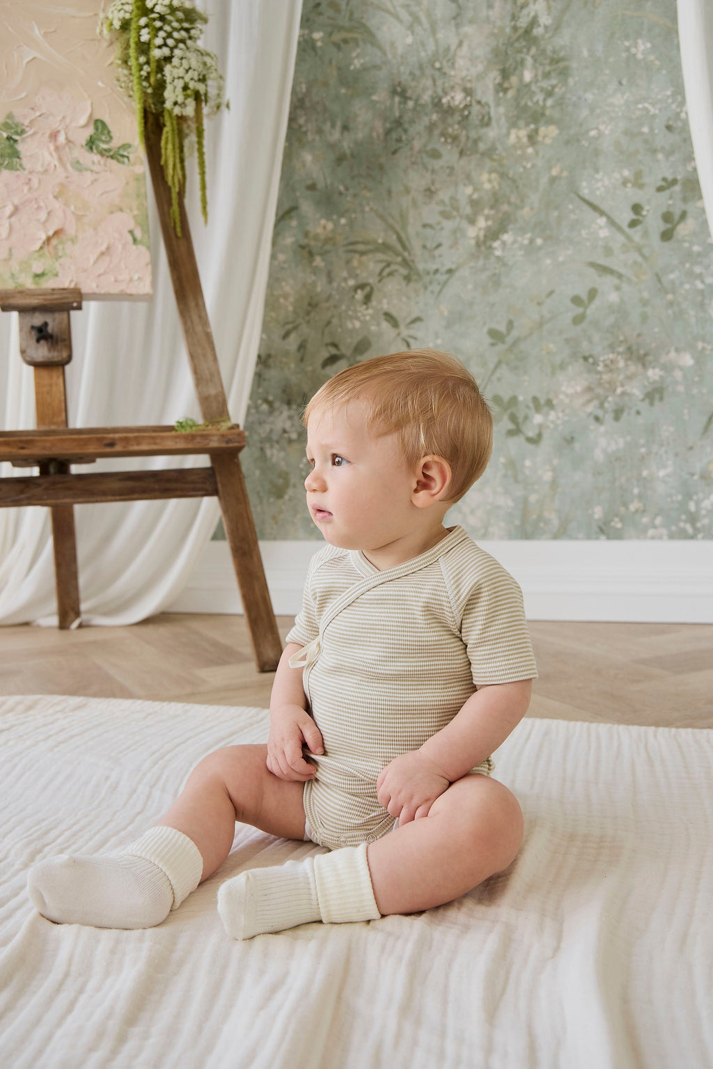 Combinaison courte bébé en coton côtelé fin à rayures crème et marron, avec ouverture cache-cœur et liens sur le côté pour le confort quotidien