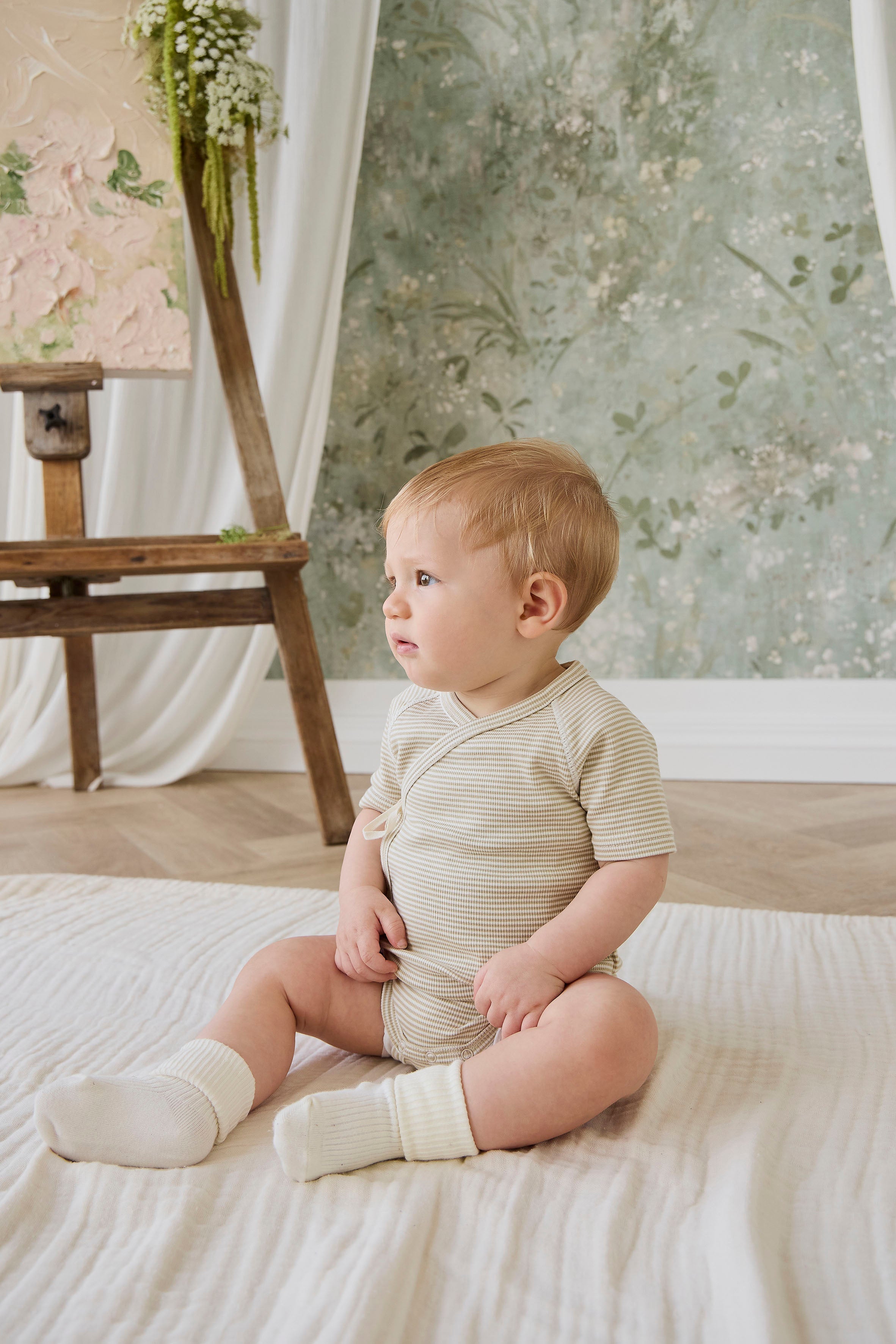 Combinaison courte bébé en coton côtelé fin à rayures crème et marron, avec ouverture cache-cœur et liens sur le côté pour le confort quotidien