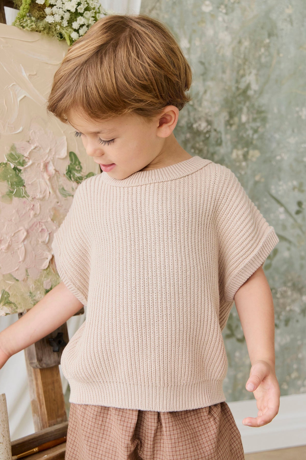 Gilet en maille pur coton, coloris sable neutre uni, à texture côtelée et manches courtes pour enfants. Idéal pour superposer ou un style décontracté.