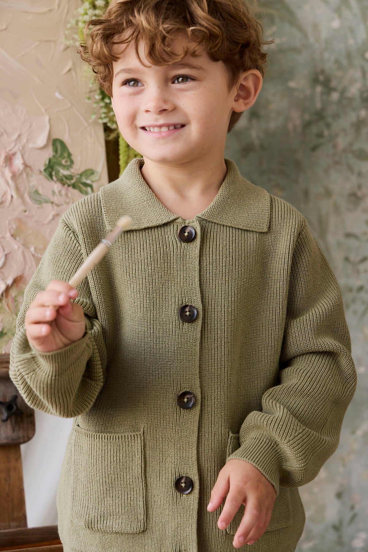 Classique = Veste en tricot de coton uni vert avec boutonnage sur le devant, poches plaquées et ourlet côtelé pour enfants