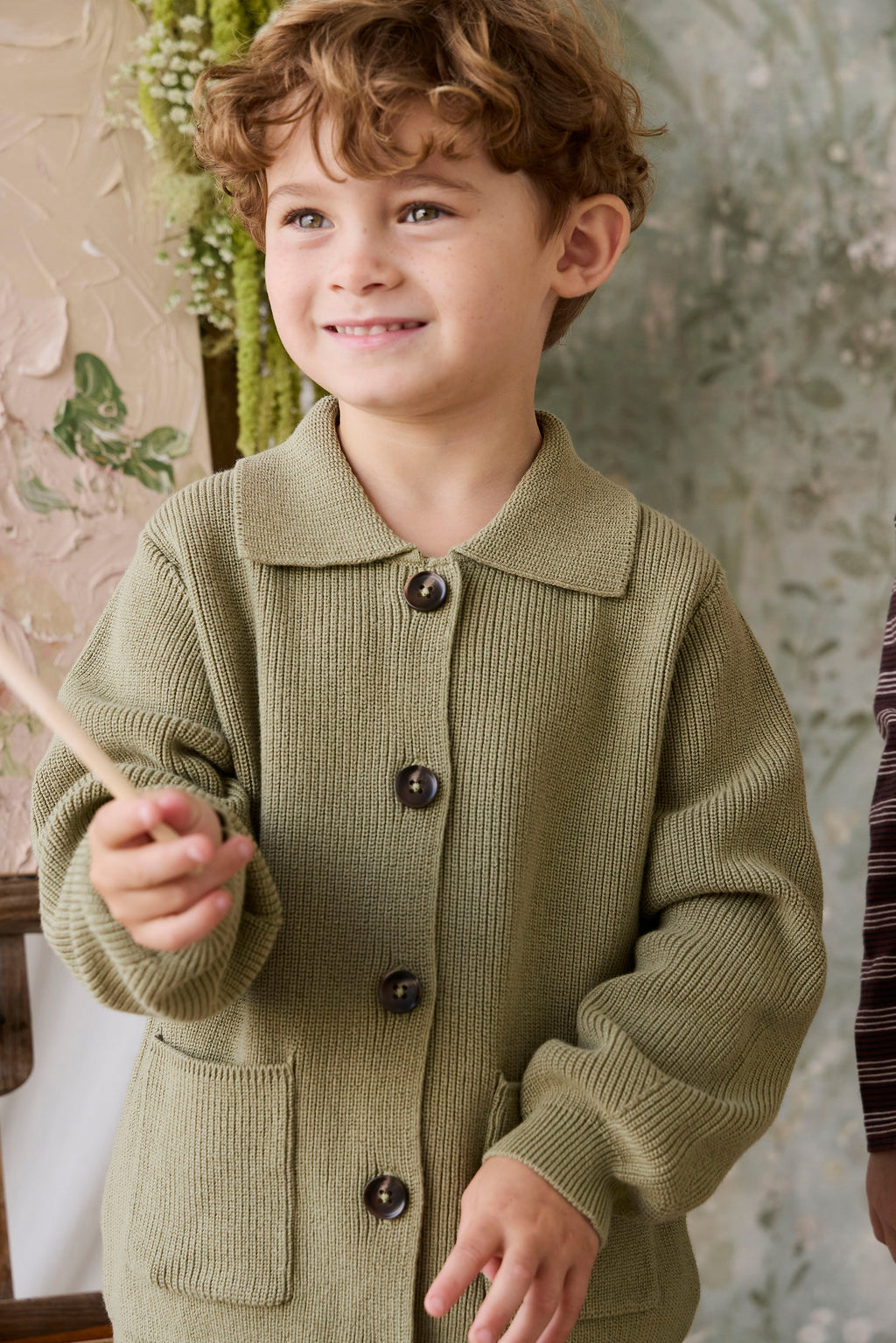 Classique = Veste en tricot de coton uni vert avec boutonnage sur le devant, poches plaquées et ourlet côtelé pour enfants