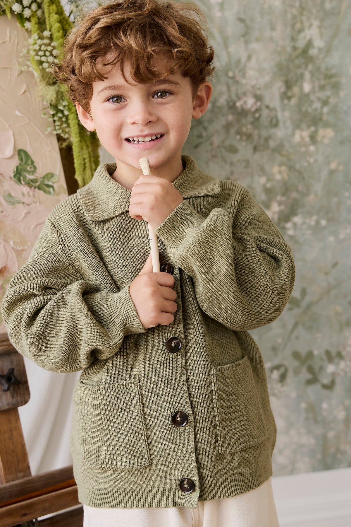 Classique = Veste en tricot de coton uni vert avec boutonnage sur le devant, poches plaquées et ourlet côtelé pour enfants