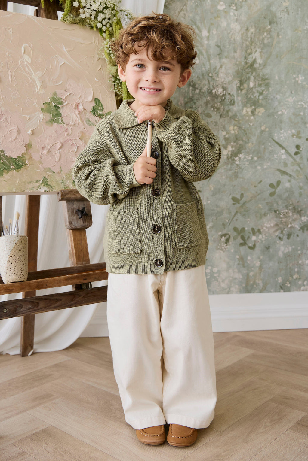 Classique = Veste en tricot de coton uni vert avec boutonnage sur le devant, poches plaquées et ourlet côtelé pour enfants