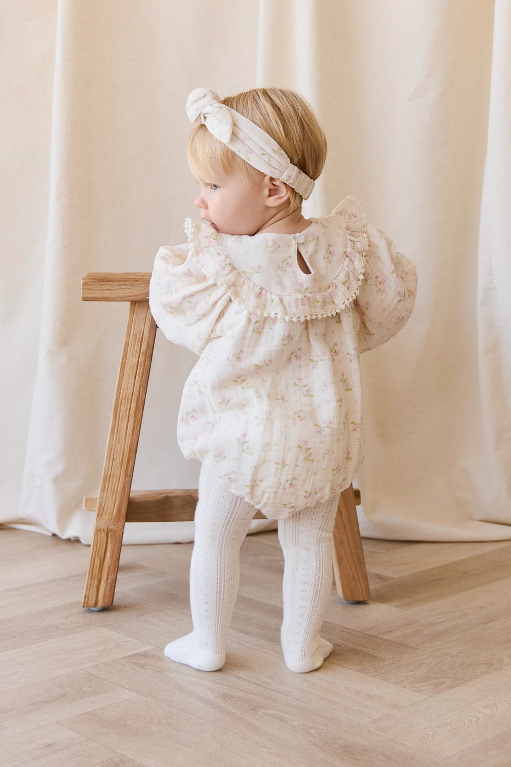 Barboteuse bébé en mousseline de coton bio à imprimé floral bohème crème, rose et vert, avec corsage froncé et ouvertures de jambes élastiquées pour temps chaud
