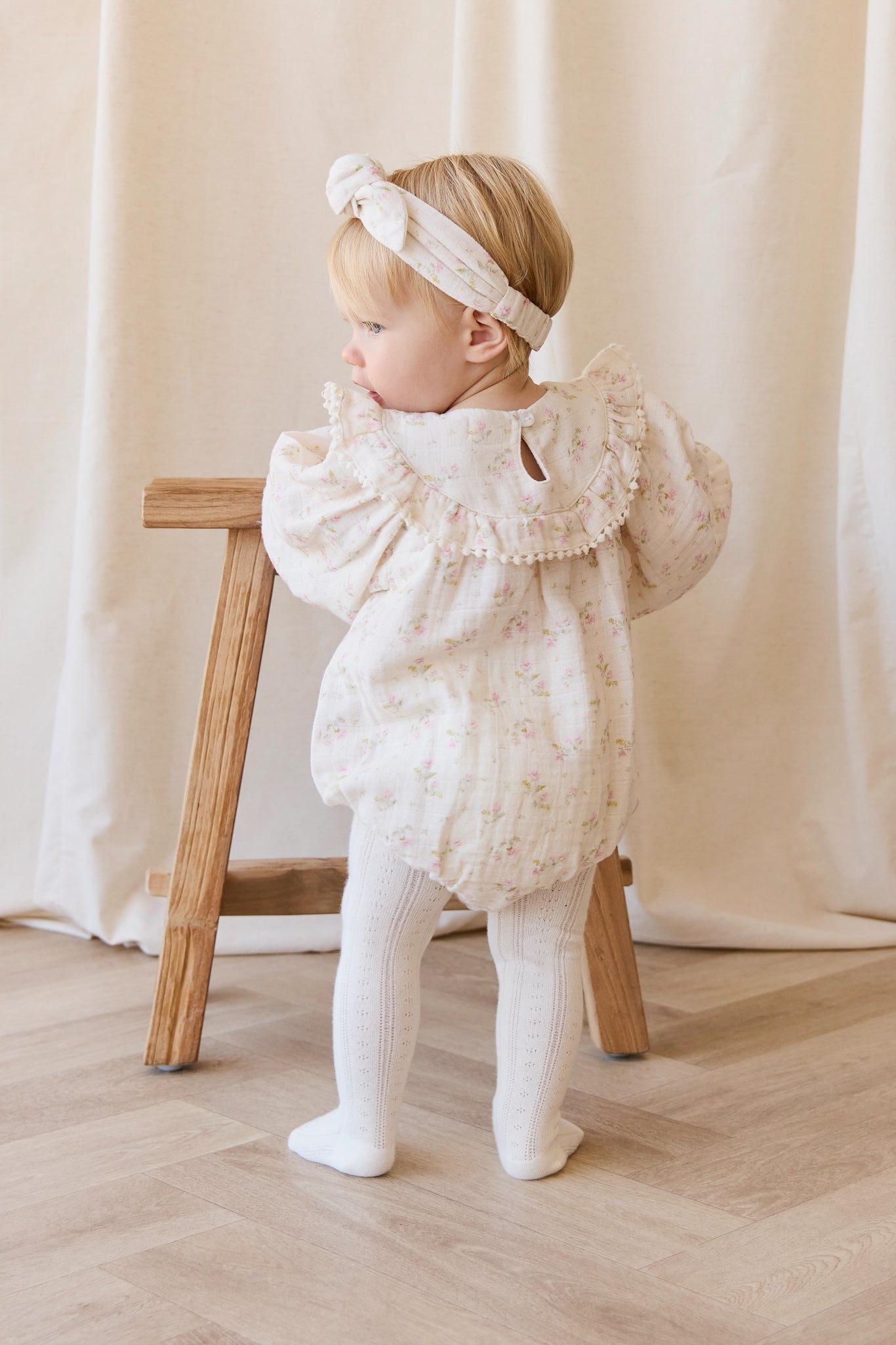 Barboteuse bébé en mousseline de coton bio à imprimé floral bohème crème, rose et vert, avec corsage froncé et ouvertures de jambes élastiquées pour temps chaud