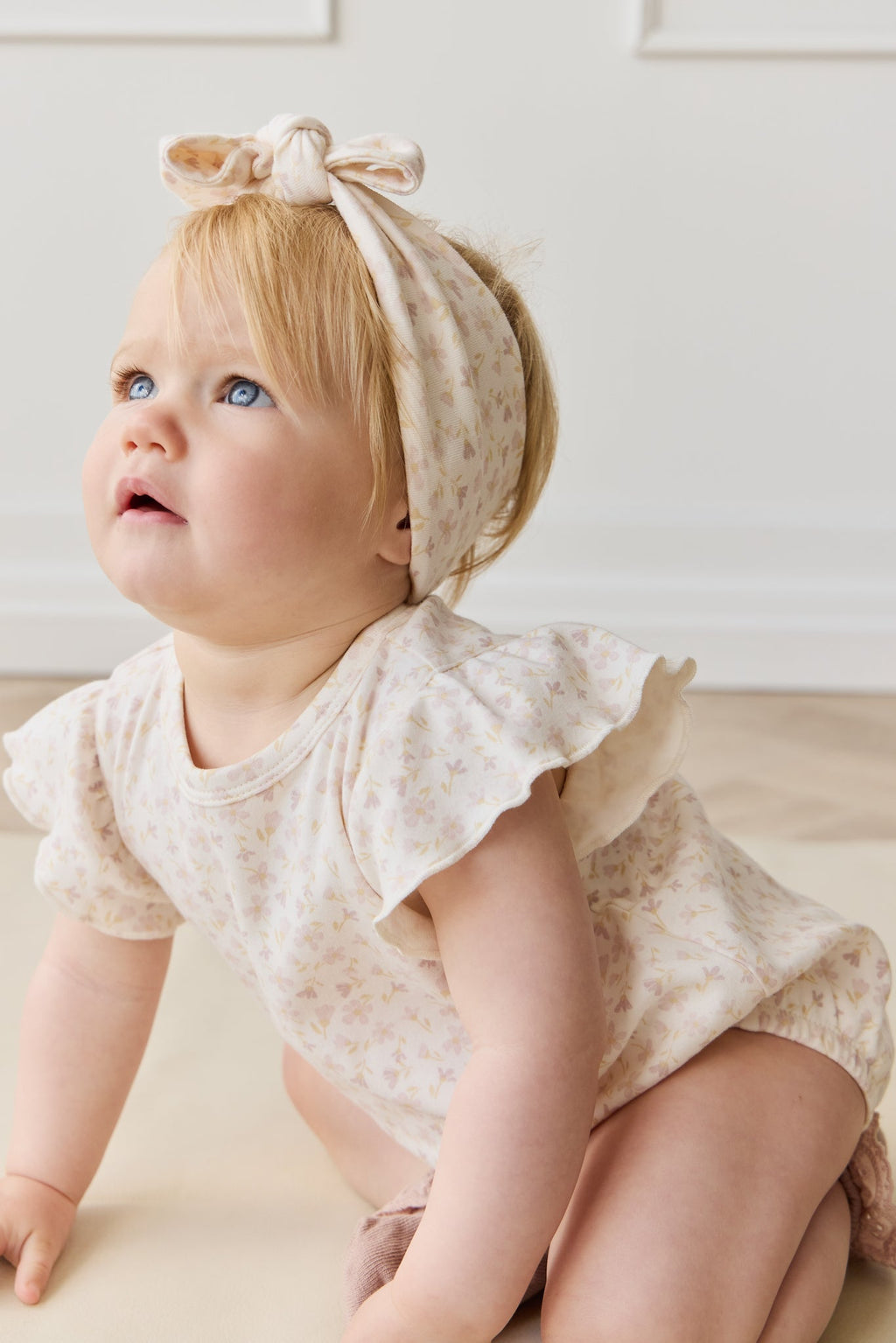 Barboteuse en coton biologique imprimé floral bohème crème et mauve, coupe décontractée confortable pour bébé et tout-petit par temps chaud
